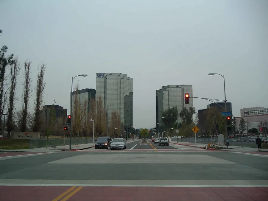 Office towers at a wide, empty intersection under an overcast sky